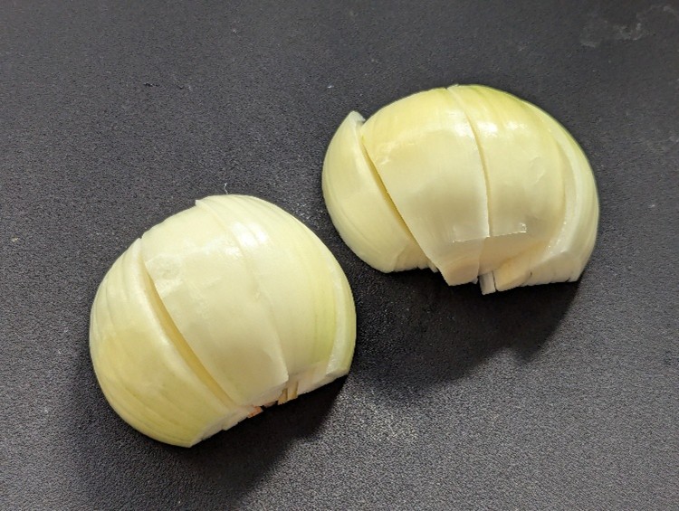 新玉ねぎの皮をむいて串切りにする